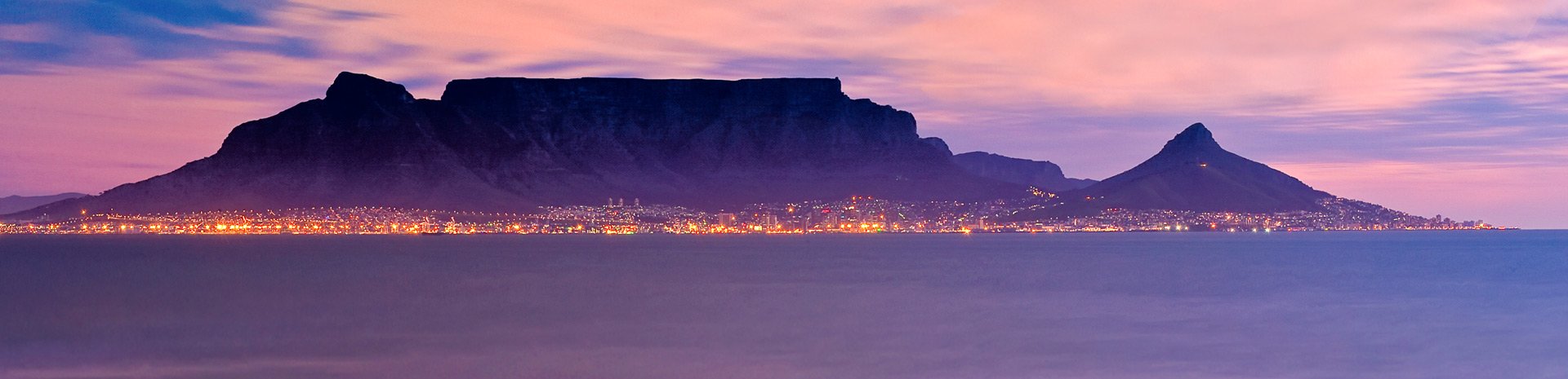 Cape Town's Table Mountain and city lights at dusk viewed from the ocean | MSC Cruises Cape Town's Table Mountain and city lights at dusk viewed from the ocean | MSC Cruises