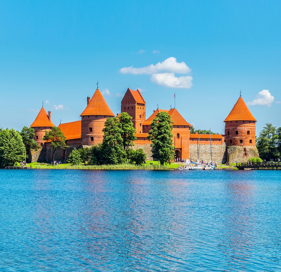 Trakai Island Castle surrounded by a serene lake under a bright blue sky | MSC Cruises