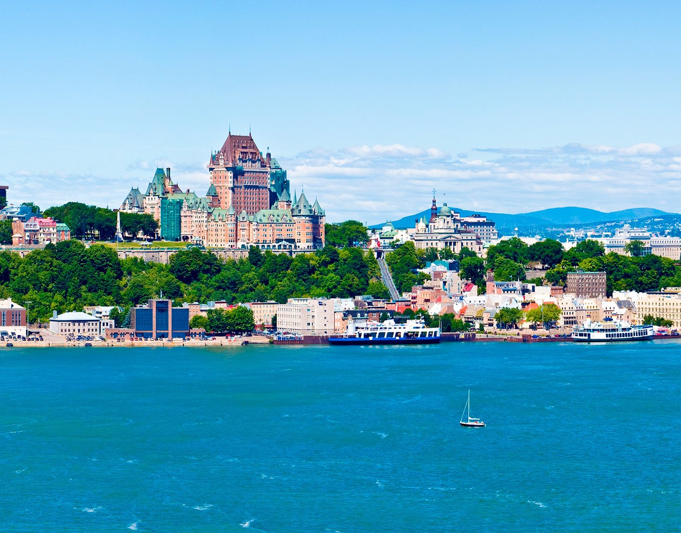 Quebec City's Château Frontenac overlooking the St. Lawrence River with a sailboat in the foreground | MSC Cruises