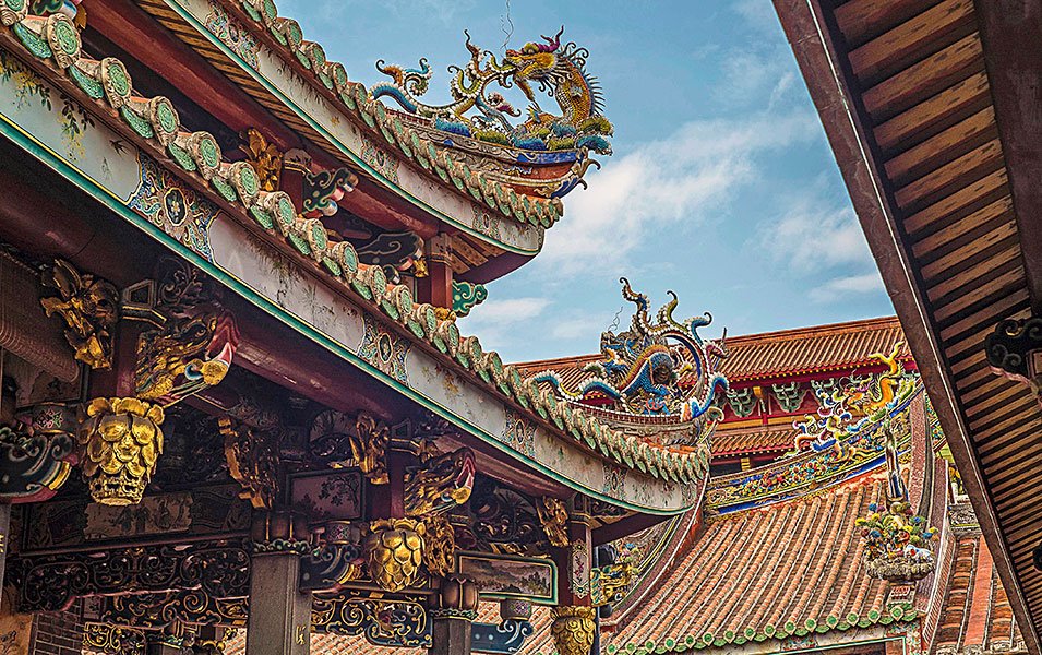 Intricate dragon-adorned temple roof under a bright sky in Asia | MSC Cruises