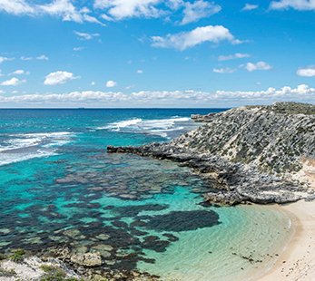 A stunning coastal view featuring clear blue waters and a sandy beach | MSC Cruises