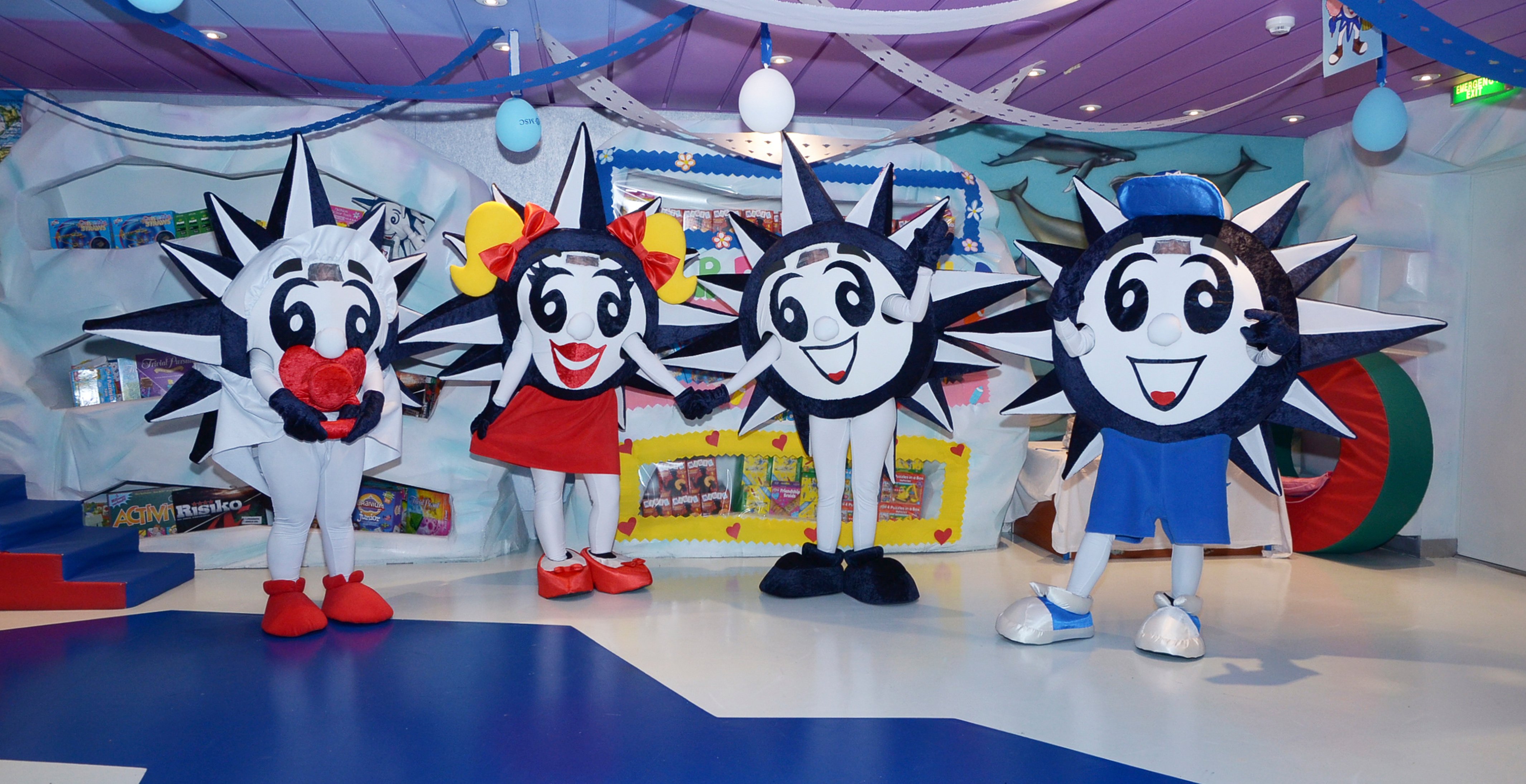 Four smiling sun mascots in a colorful kids' play area onboard | MSC Cruises