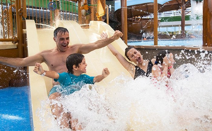 Family enjoying a waterslide splash on a cruise ship | MSC Cruises Family enjoying a waterslide splash on a cruise ship | MSC Cruises