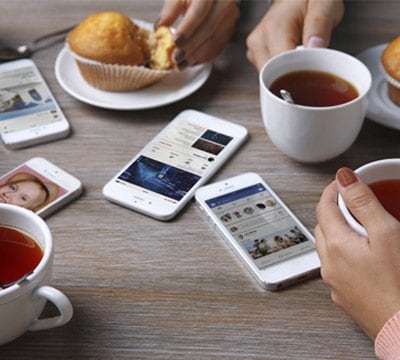 Smartphones displaying MSC Cruises website and apps on a table with tea and muffins | MSC Cruises Smartphones displaying MSC Cruises website and apps on a table with tea and muffins | MSC Cruises