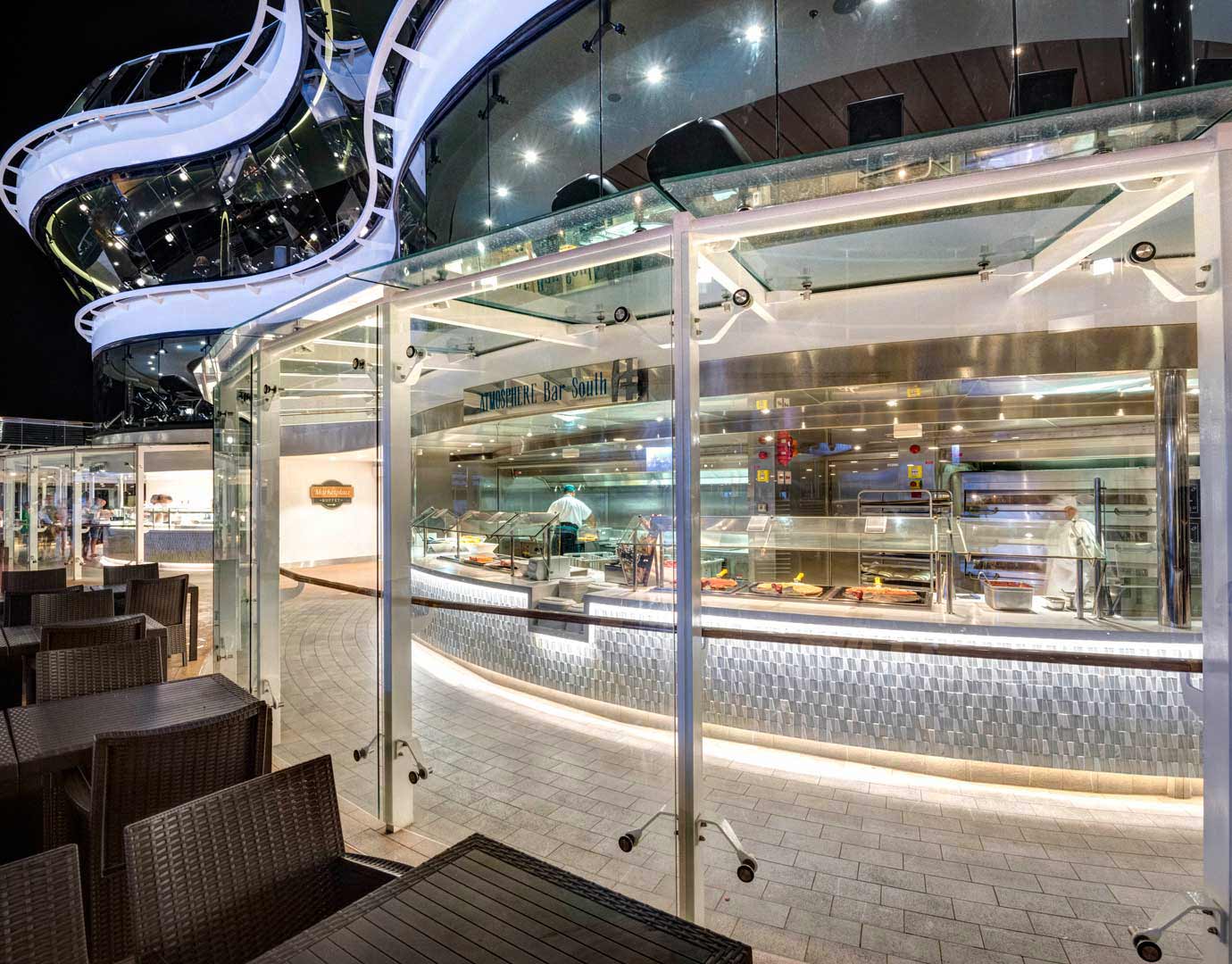Outdoor buffet dining area on an MSC cruise ship at night with modern architecture and seating | MSC Cruises Outdoor buffet dining area on an MSC cruise ship at night with modern architecture and seating | MSC Cruises