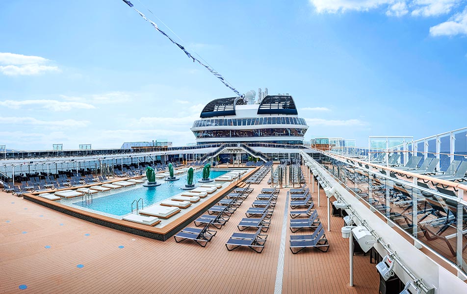 A luxurious pool deck with sun loungers on an MSC cruise ship under a clear blue sky | MSC Cruises A luxurious pool deck with sun loungers on an MSC cruise ship under a clear blue sky | MSC Cruises