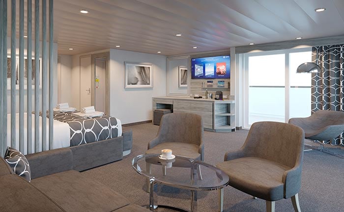 Spacious cruise suite with modern decor, seating area, and private balcony overlooking the ocean | MSC Cruises Spacious cruise suite with modern decor, seating area, and private balcony overlooking the ocean | MSC Cruises