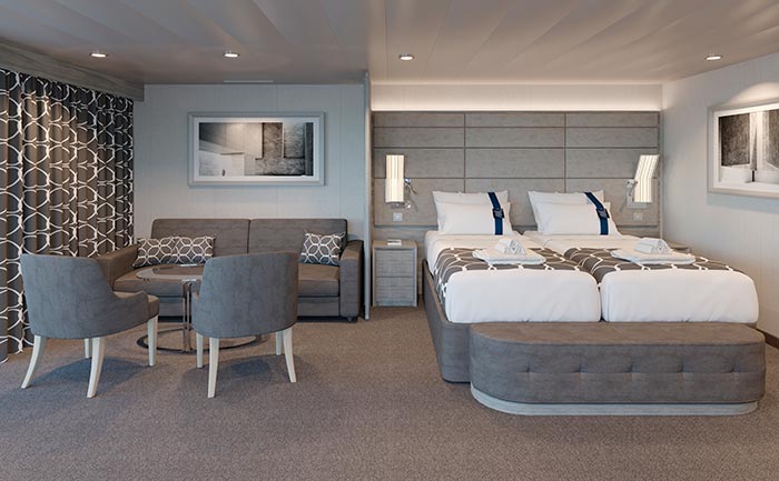 Spacious cruise ship cabin with twin beds, sofa, and modern decor | MSC Cruises Spacious cruise ship cabin with twin beds, sofa, and modern decor | MSC Cruises